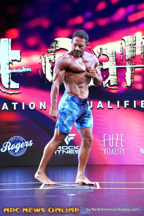 Men's Physique side pose during the show-day competition